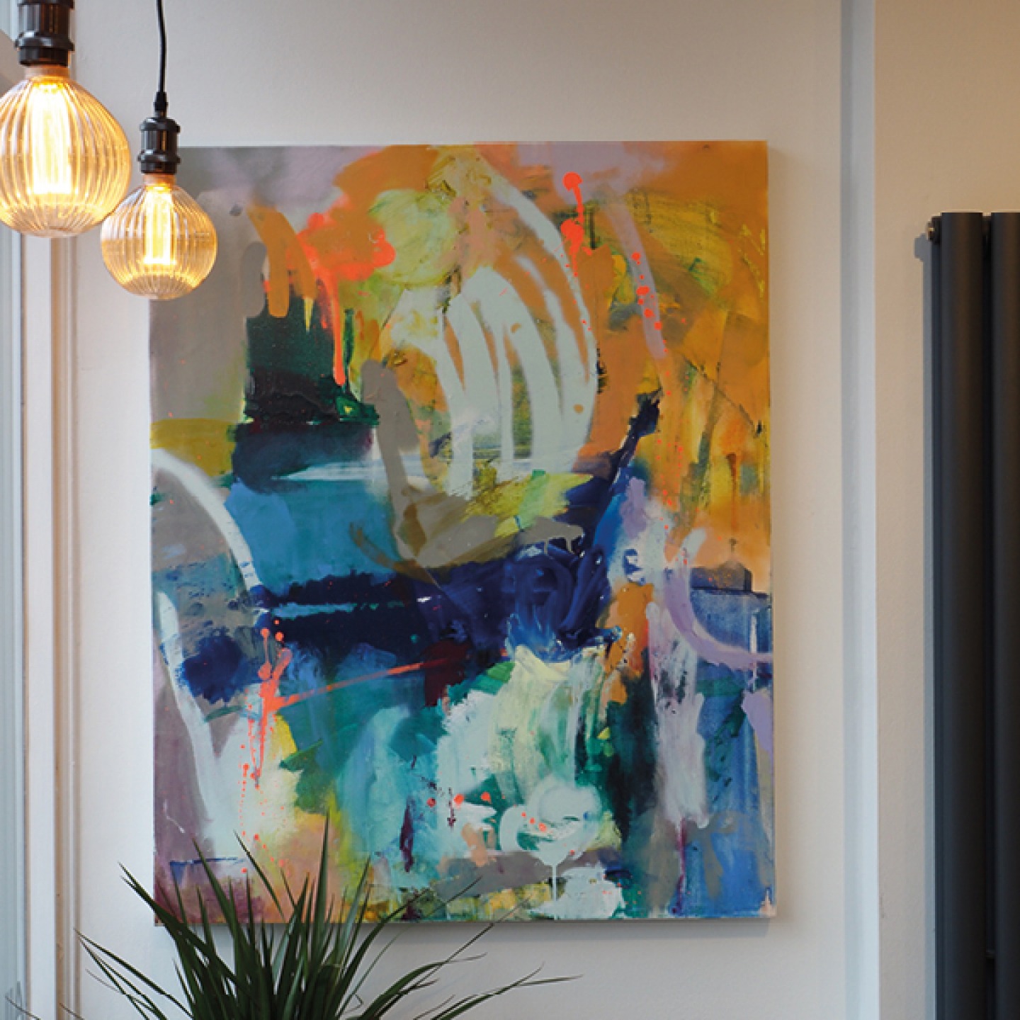 blue, yellow, orange and white abstract painting hanging on cafe wall