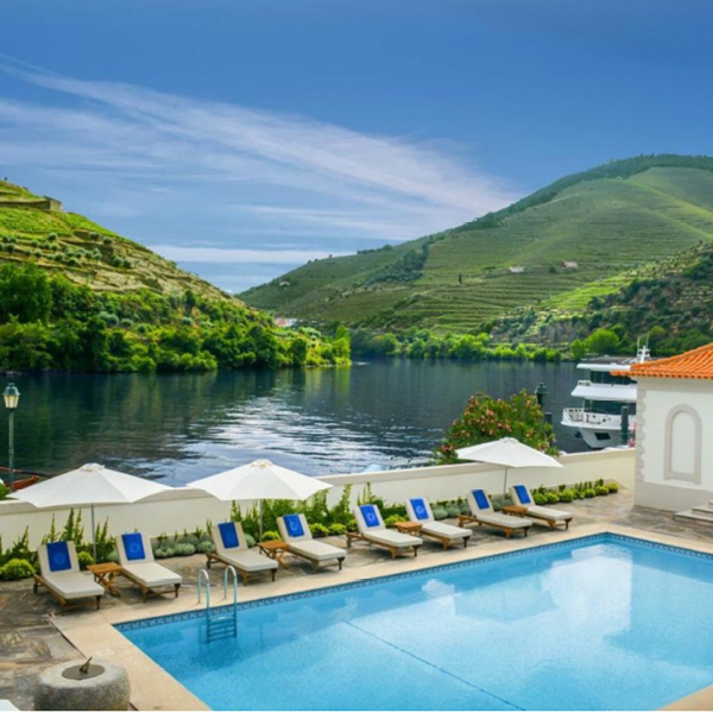 poolside with loungers looking over the river and vineyards